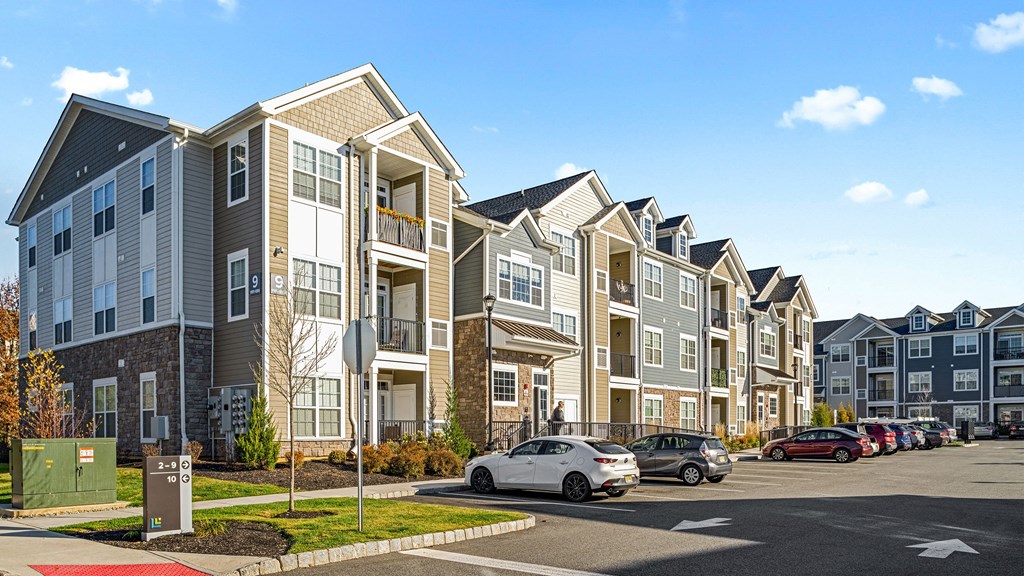a row of town houses with cars parked in front of them