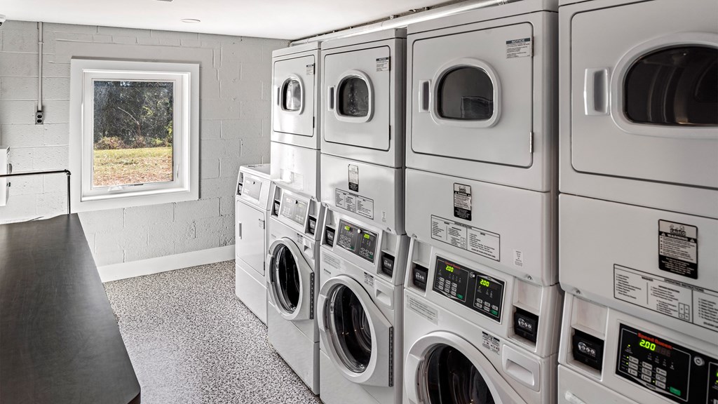 a row of washers and dryers in a laundry room