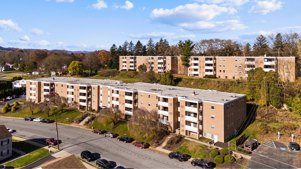 an aerial view of an apartment building with a parking lot