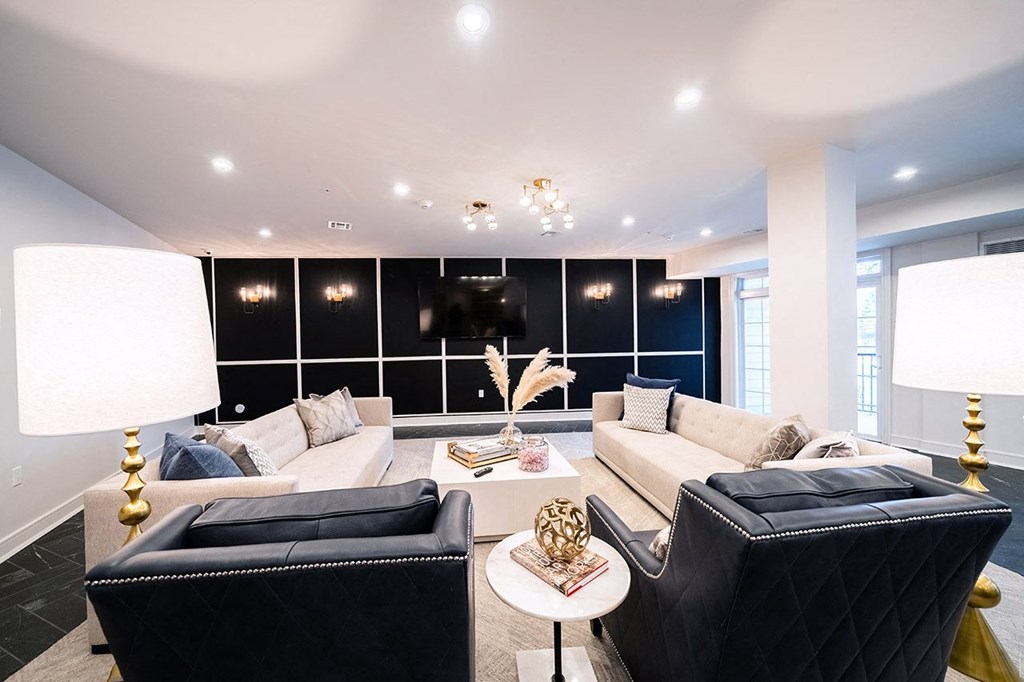 a living room with black and white furniture and a tv