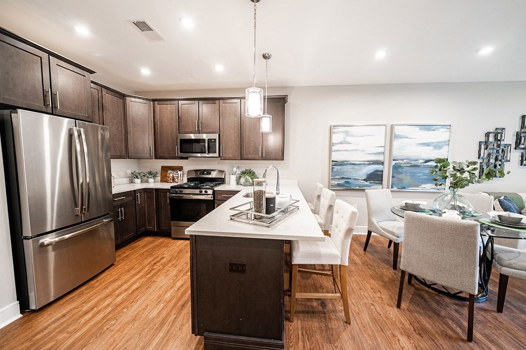 a kitchen and dining room with stainless steel appliances and wood flooring