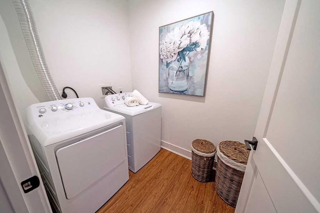 a laundry room with a washer and dryer and a painting on the wall