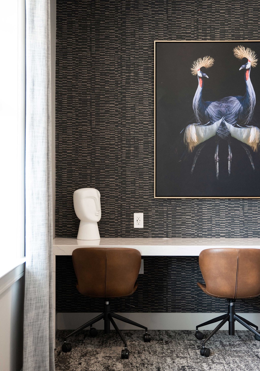 a bathroom with two brown chairs and a painting of two peacocks