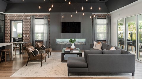 a living room with a gray couch and a table with chairs