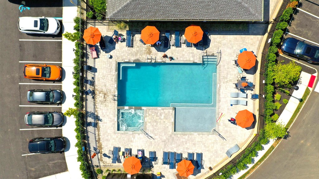a birds eye view of a pool in a hotel with umbrellas