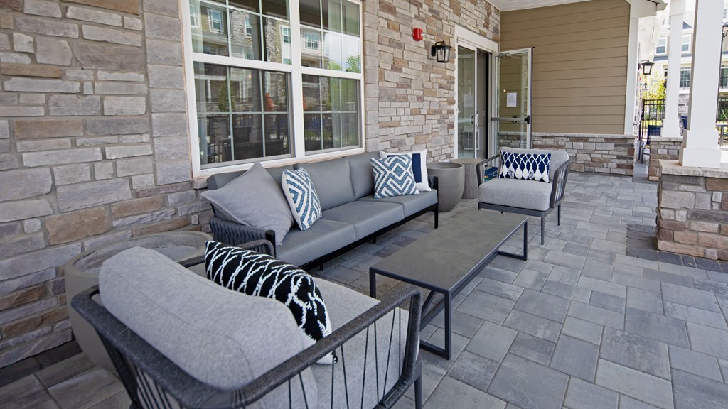 a patio with couches and tables outside of a house
