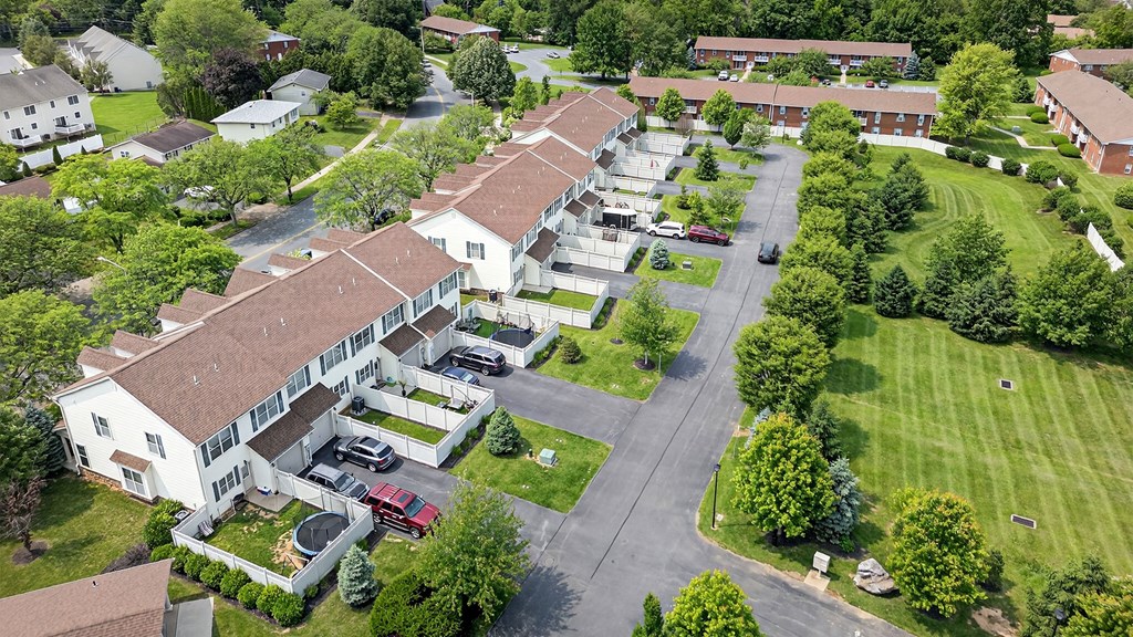 A bird's eye view of a residential area with houses and parked cars.