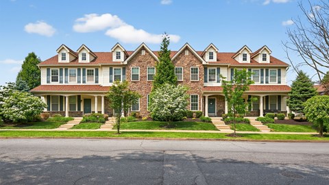 A large, two-story house with a brick facade and a red roof.