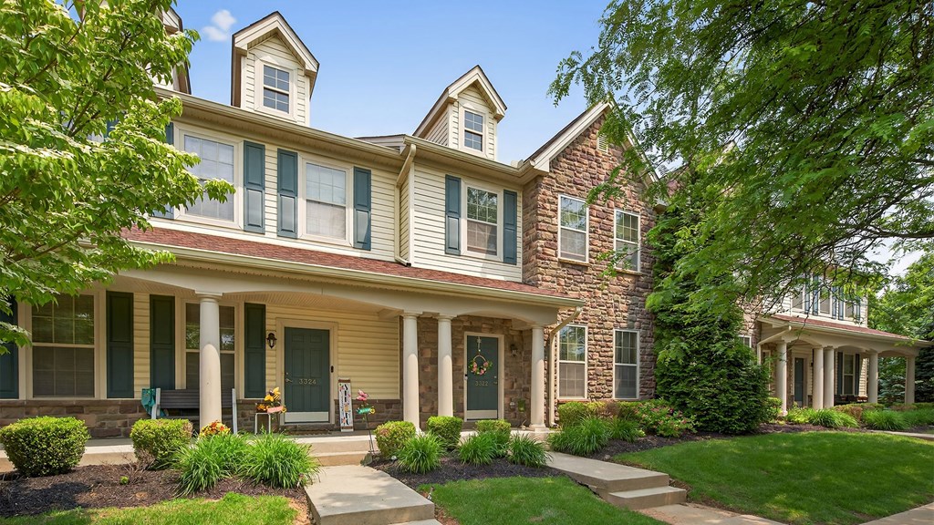 A large house with a front porch and a green door.
