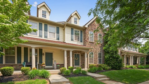 A large house with a front porch and a green door.