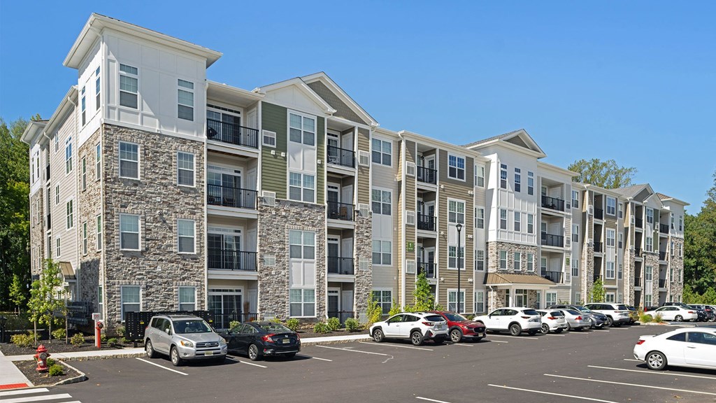 a large apartment building with cars parked in a parking lot