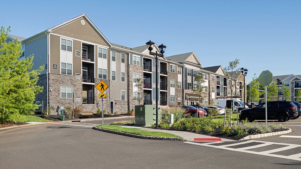 an apartment building with cars parked in a parking lot