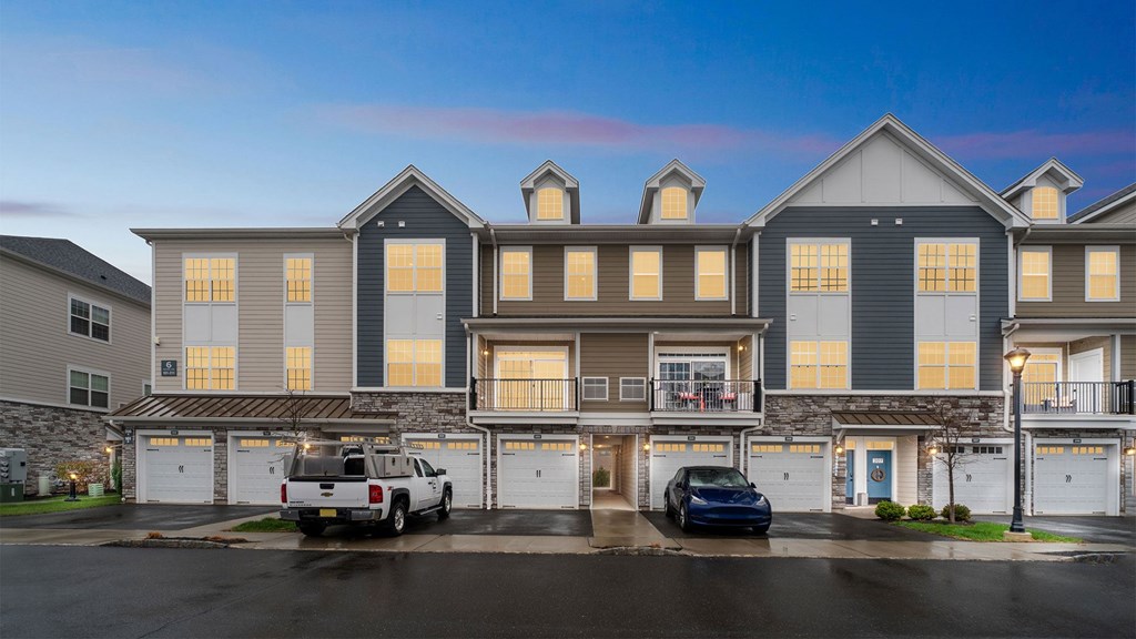 A large, modern building with multiple garages and a car parked in front.