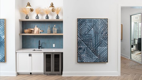a kitchen with white cabinets and a sink and a blue wall