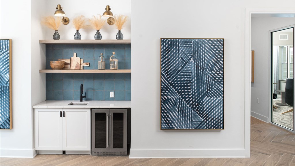 a kitchen with white cabinets and a sink and a blue wall