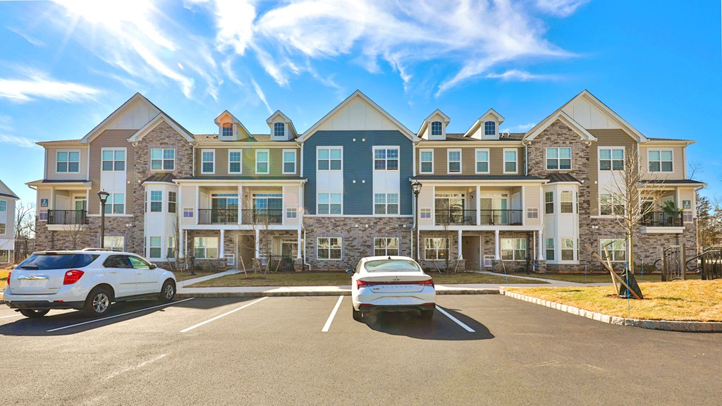 a parking lot with cars in front of an apartment building