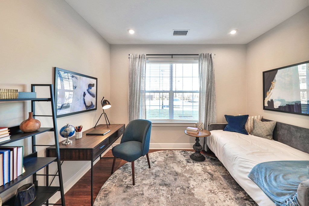 a bedroom with a bed and a desk and a window