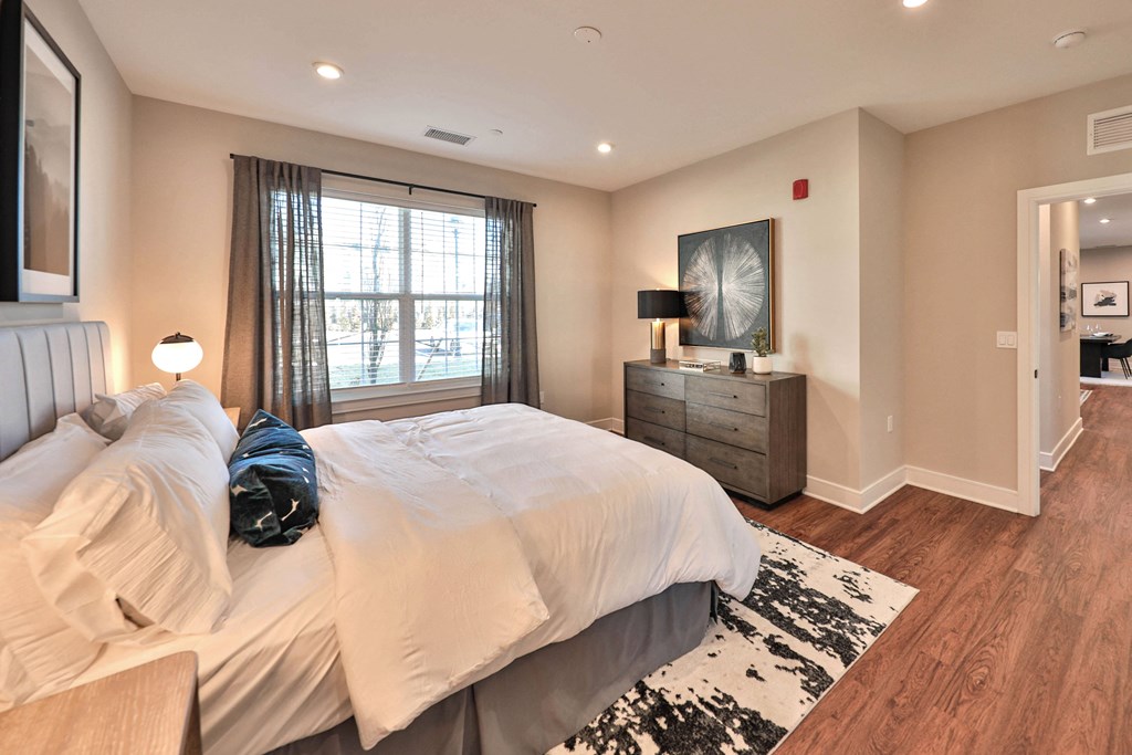 a bedroom with a bed and a dresser and a window