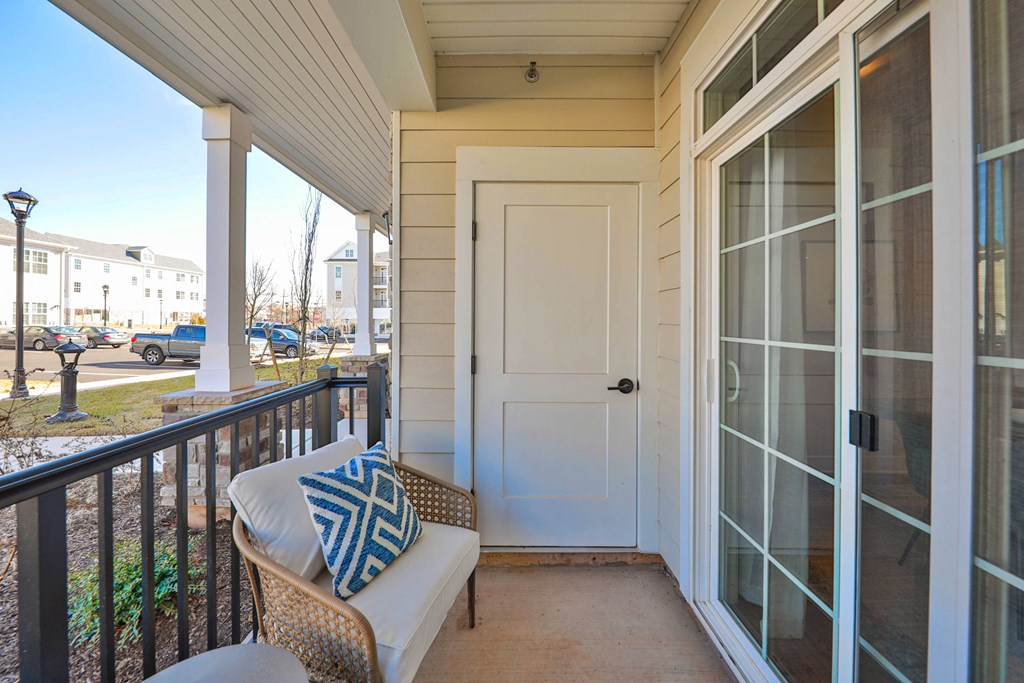 a front porch with a chair and a white door