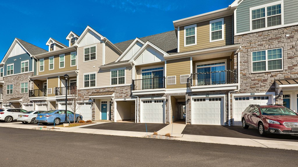a row of houses with cars parked in front of them