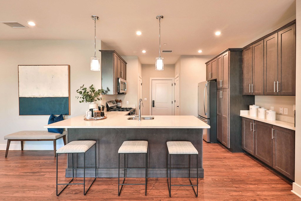 a kitchen with a large island with three stools