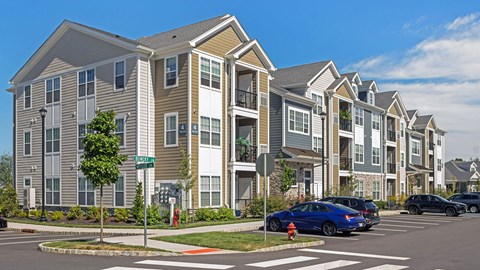 a row of townhouses with cars parked in a parking lot