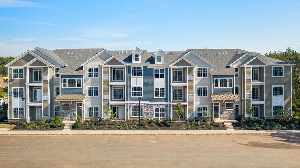 an apartment building with a parking lot in front of it