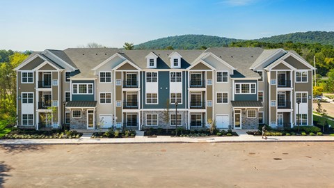 A large building with multiple windows and doors is surrounded by a parking lot.