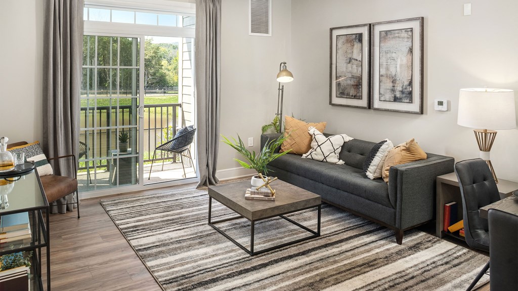 a living room with a couch and a coffee table and a door to a balcony