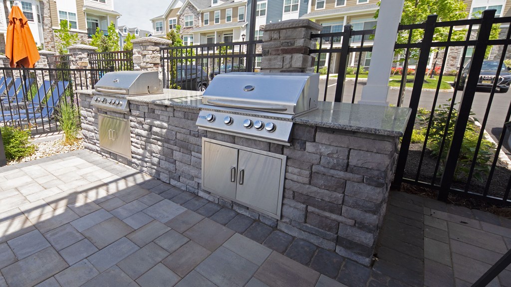 a stone outdoor kitchen with two stoves on a patio