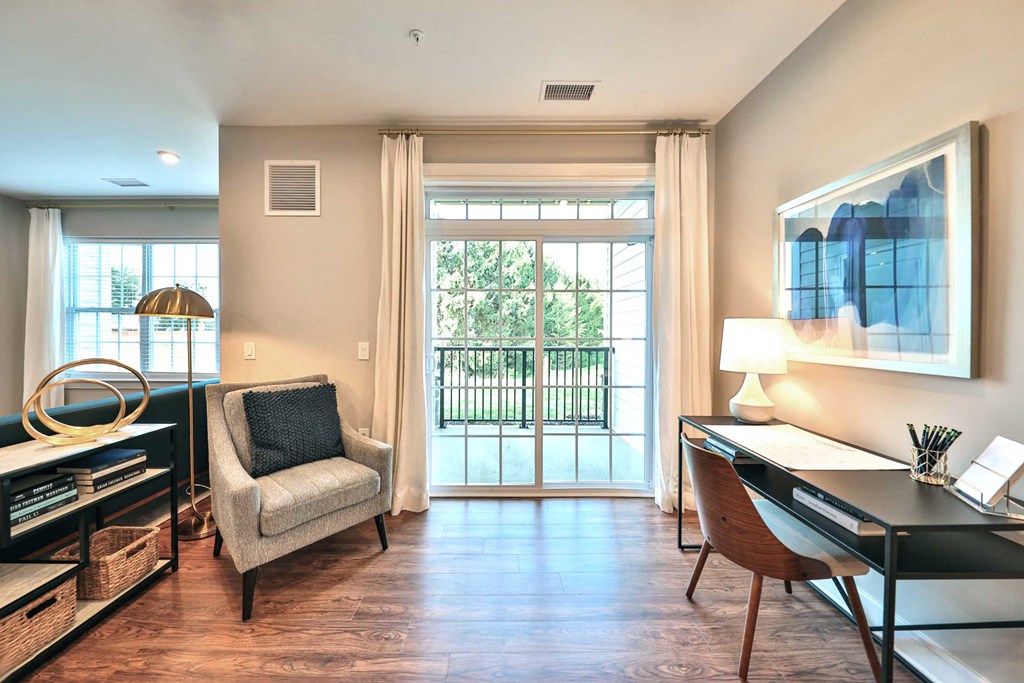 a home office with a desk and a sliding glass door