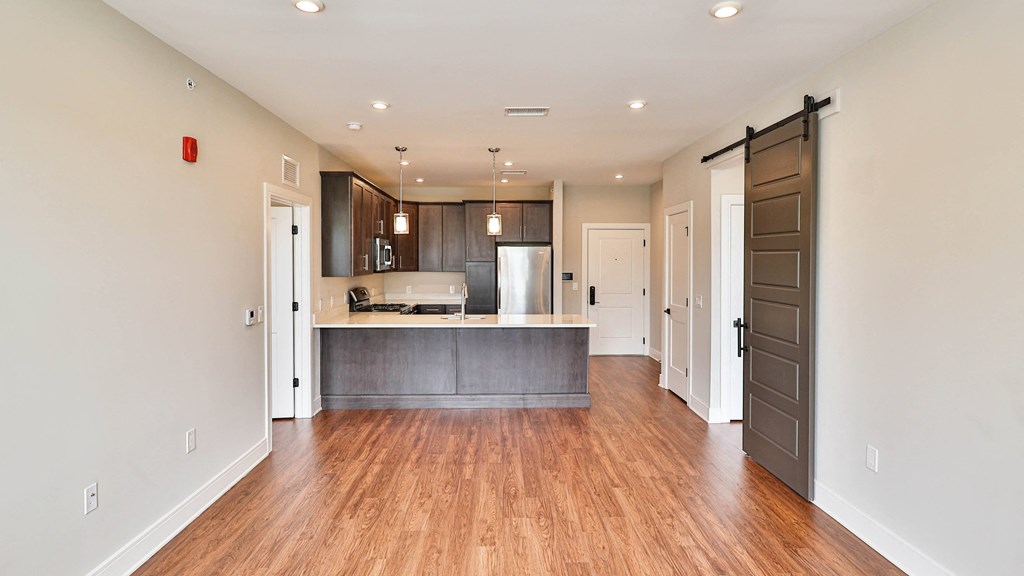 a renovated living room and kitchen with a hard wood floor