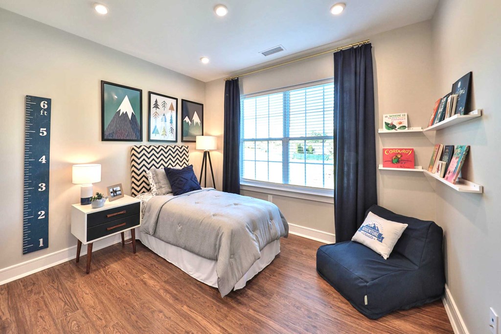 a bedroom with a bed and a desk and a window