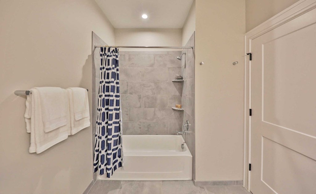 a white bathroom with a shower and a tub