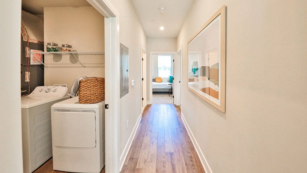 a laundry room with a washer and dryer and a door to a bedroom