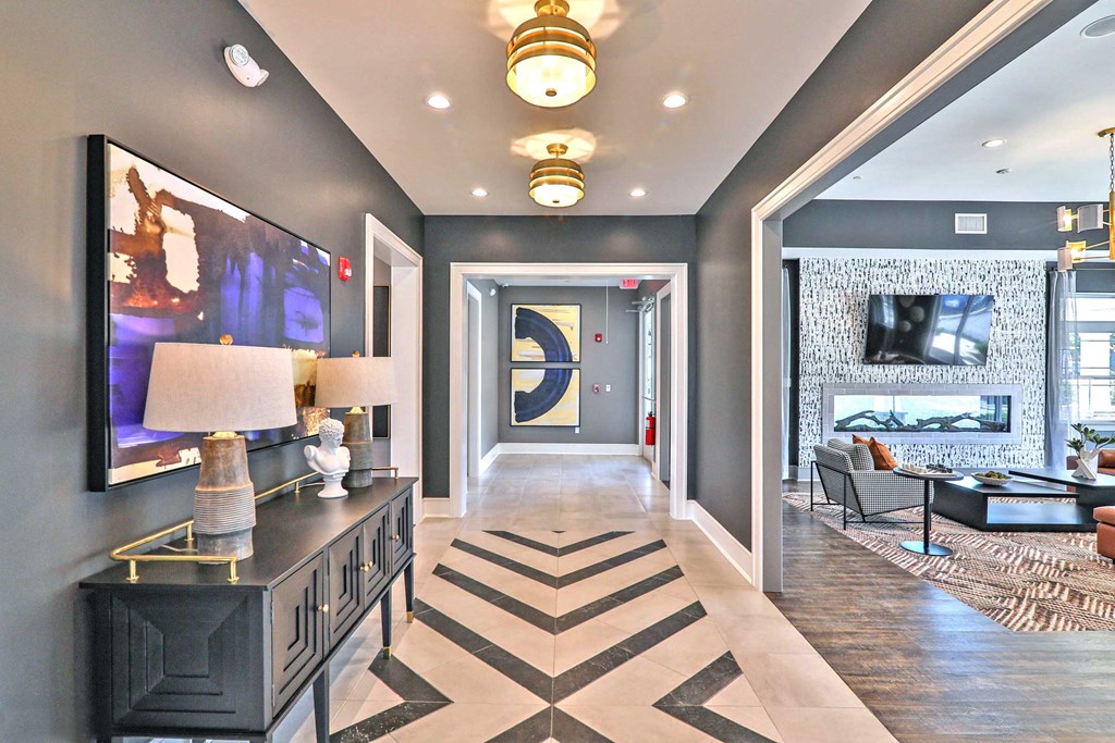 a long hallway with a large painting on the wall and a lobby with couches