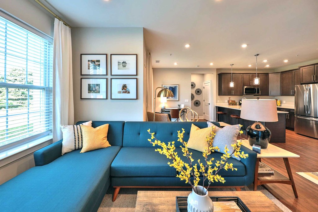 a living room with a blue couch and yellow pillows