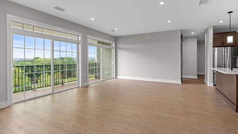A spacious room with a view of trees through the windows.