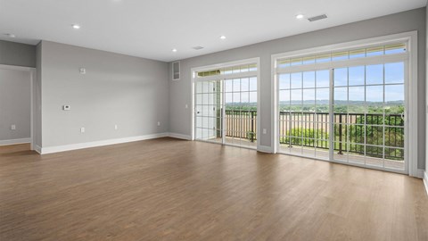 A room with a sliding glass door leading to a balcony.