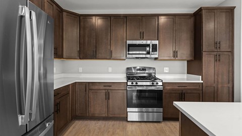 A modern kitchen with a stainless steel refrigerator and wooden cabinets.