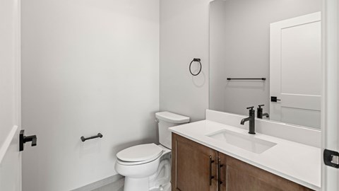 A white toilet sits next to a sink in a bathroom.