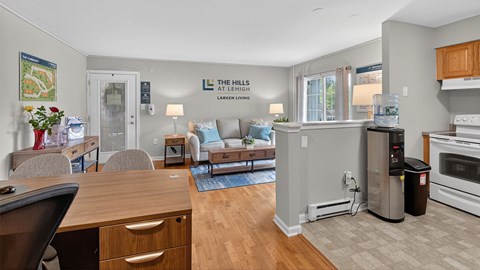 A well-lit kitchen and living room with a dining table and chairs.
