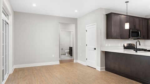 A kitchen with dark brown cabinets and a white counter.