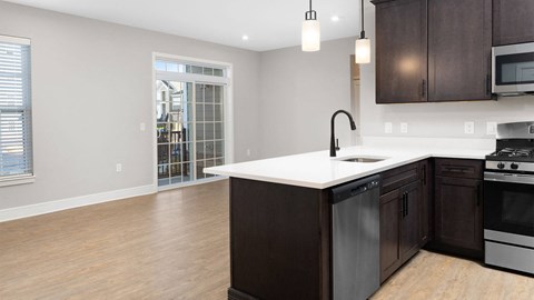 A kitchen with dark wood cabinets and a white countertop.