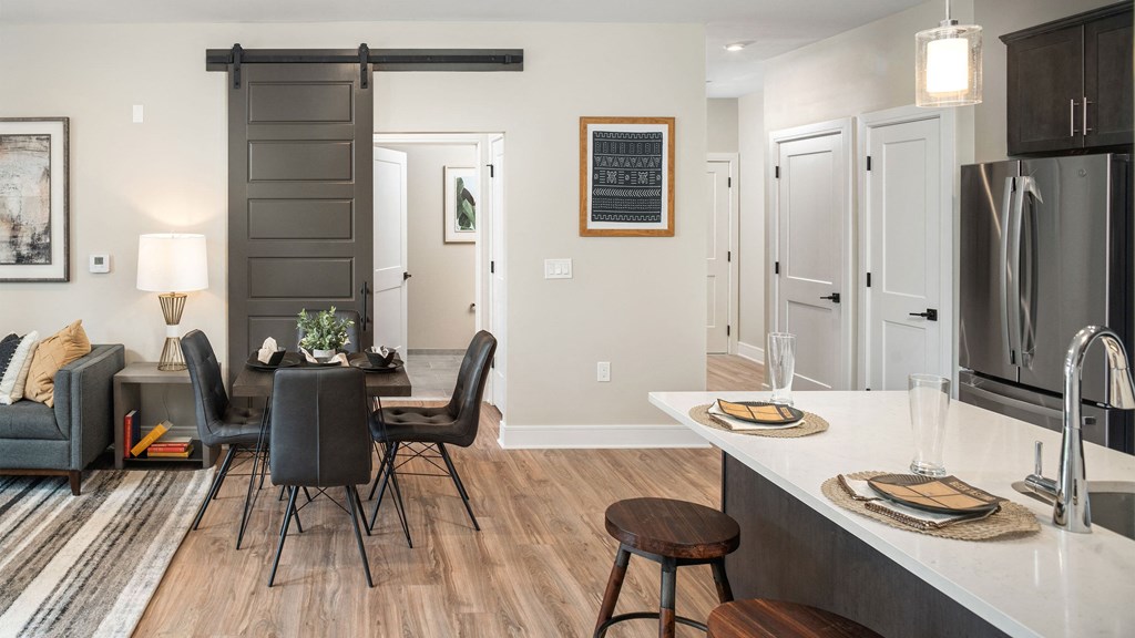a kitchen and living room with a table and chairs and a refrigerator