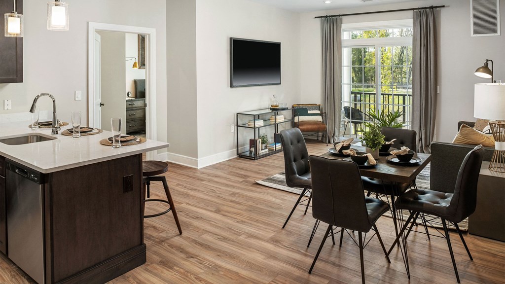 a living room and dining room with a table and chairs and a television
