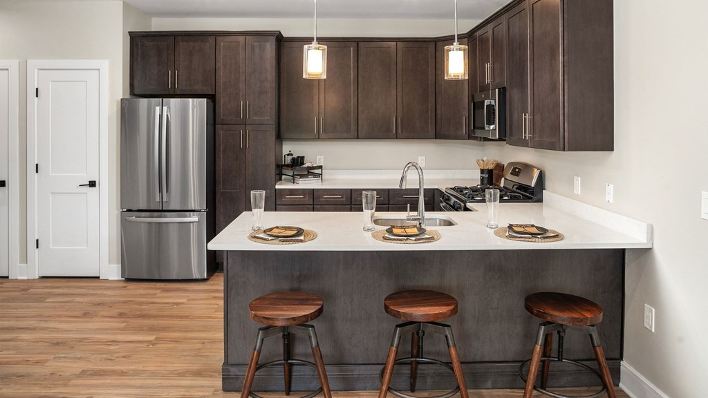a kitchen with a center island with three stools
