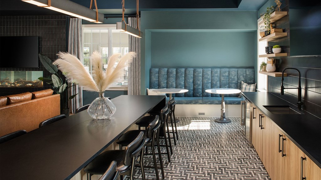 a dining room with a long table and chairs and a blue couch