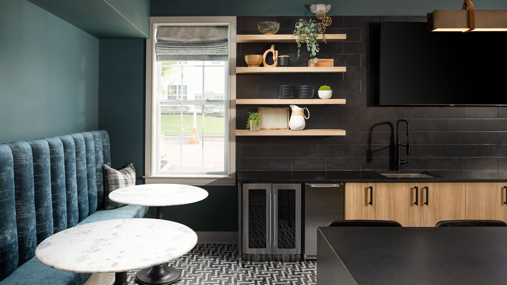 a small kitchen with blue walls and a table and chairs