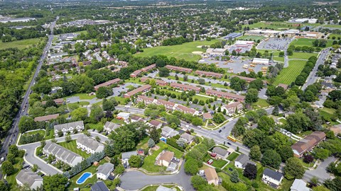 An aerial view of a residential area with apartment buildings and a swimming pool.